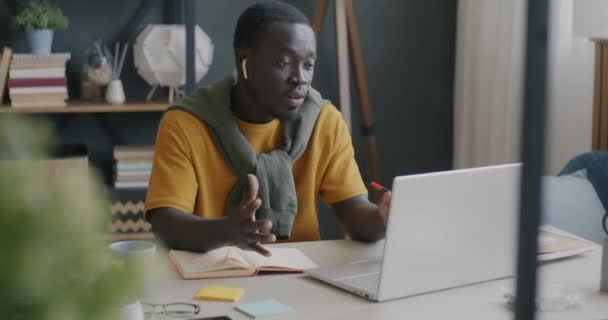 Öğrenci Afrikalı Afrikalı Amerikalı Evde Bilgisayar Kablosuz Kulaklıkla Yazıp Konuşuyor — Stok video