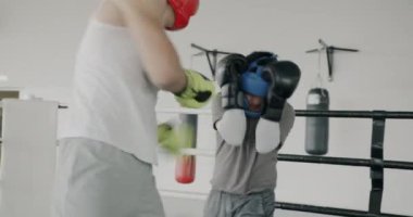 Yetenekli boksörler spor giyim eğitimi almış genç erkekler spor yaparken yumruk pratiği yapıyorlar. Dövüş sanatları ve aktif yaşam tarzı kavramı.