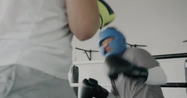 İki genç boksör spor salonunda eldiven ve kask takarak antrenman yapıyor. Aktif yaşam tarzı ve dövüş sanatları konsepti.