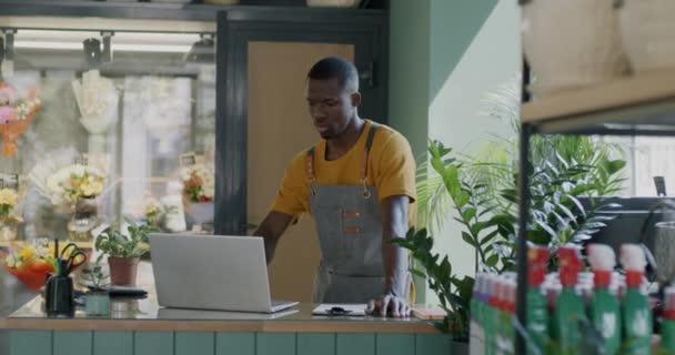 Mitarbeiter Des Blumengeschäfts Die Mit Laptop Computern Arbeiten Und Pflanzen — Stockvideo