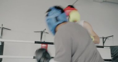 Spor salonunda antrenman yapan iki erkek eldiven ve kask takıyor. Profesyonel spor ve insan konsepti.