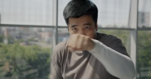 アジア人男性の肖像画は拳でパンチし ガラス壁のジムでカメラトレーニングを見ています ボクシングとプロスポーツコンセプト — ストック動画
