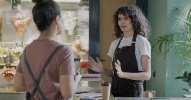 Dos Mujeres Jóvenes Delantales Floristas Hablando Pie Mostrador Con Plantas — Vídeos de Stock