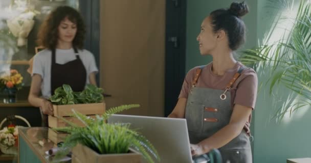 Propietaria Negocio Flores Usando Computadora Mientras Trabajadora Entregando Plantas Frescas — Vídeos de Stock