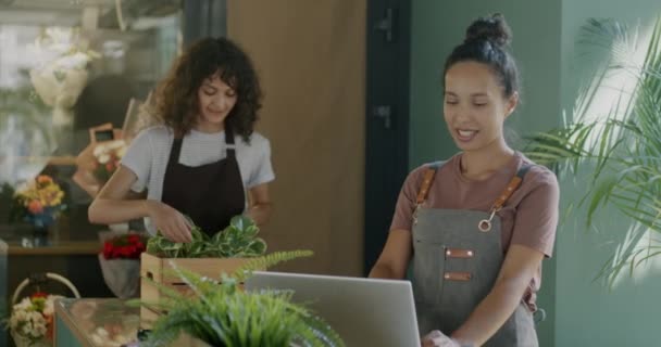 Молодые Женщины Цветочного Магазина Работают Ноутбуками Печатая Принося Свежие Зеленые — стоковое видео