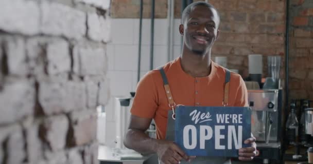 Портрет Веселого Бариста Афроамериканца Стоящего Кафе Держа Открытой Доске Улыбаемся — стоковое видео