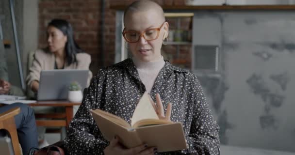 Медленный Кинопортрет Молодой Предпринимательницы Читающей Книгу Улыбающейся Сидящей Творческом Кафе — стоковое видео