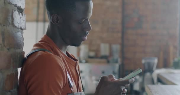 Afroamerykanin Barista Pomocą Aplikacji Smartfon Dotyka Ekranu Uśmiecha Się Kawiarni — Wideo stockowe