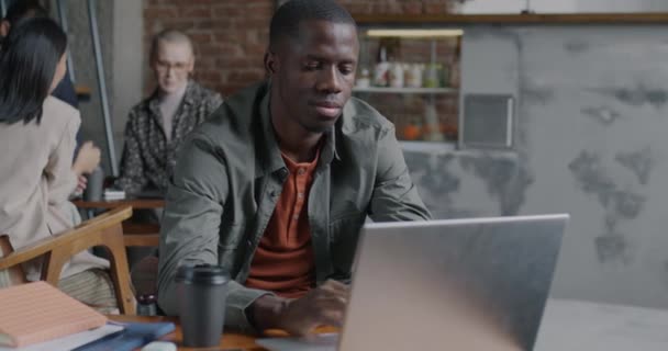 有野心的非洲裔美国人企业家坐在咖啡店里 带着笔记本电脑微笑工作 现代技术和远程工作概念 — 图库视频影像