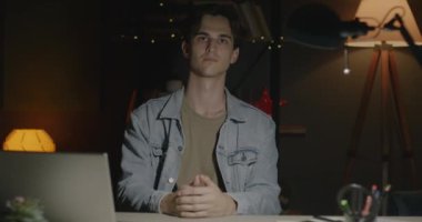 Karanlık bir dairede tek başına oturmuş kameraya bakan dalgın bir gencin portresi. İnsani duygular ve evdeki insanlar.