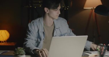 Bütün gece bilgisayar kullanarak ve işe yoğunlaşan iş belgelerini kontrol ederek ofiste çalışan motive olmuş bir çalışan. Aşırı çalışma ve iş adamı konsepti.