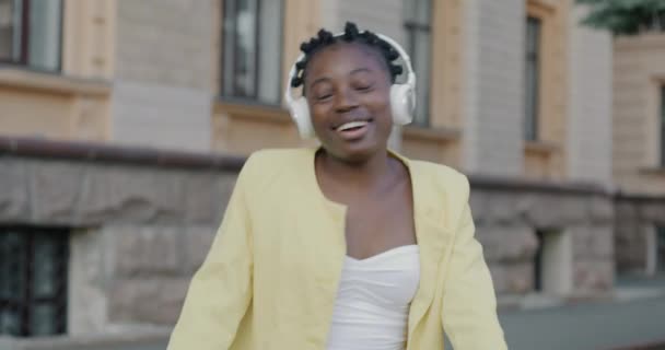 Повільний Рух Грайливої Молодої Жінки Слухає Музику Через Бездротові Навушники — стокове відео