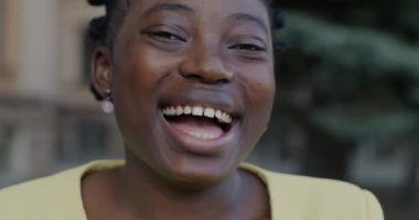 Aşırı mutlu Afro-Amerikan bir kadının şehir sokaklarında eğlenirken çekilmiş yavaş çekimde çekilmiş portresi. Duygu ve mutlu insanlar konsepti.