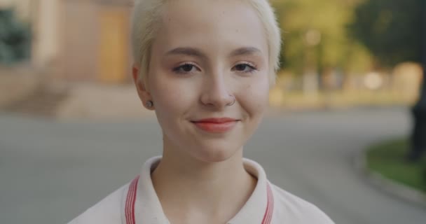 Powolny Portret Wesołej Blondynki Przeszywającym Uśmiechem Patrzącej Kamerę Świeżym Powietrzu — Wideo stockowe