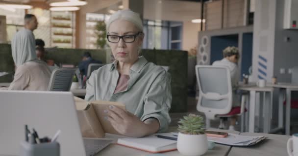 仕事休憩中にオフィスでリラックスした理性的な成熟した女性読書ビジネス教育に集中 人と文学の概念 — ストック動画