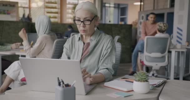 自信成熟的女商人在开放的办公室里从事公司活动的笔记本电脑打字工作 技术和雇员概念 — 图库视频影像