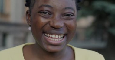 Açık havada mutluluğu ifade eden neşeli Afro-Amerikalı kadının yakın plan portresi. Neşeli insan ve pozitif duygu kavramı.