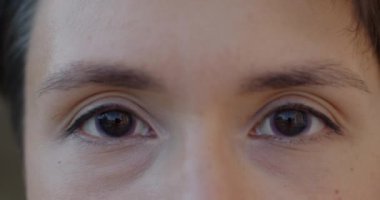 Kontakt lens takan ve arka planda bulanık duran kameraya bakan kadın gözlerinin yakın çekimi. Güzel insan yüzü ve vizyon kavramı.