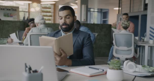 Nahöstlicher Mann Anzug Liest Buch Bei Der Arbeit Und Entspannt — Stockvideo