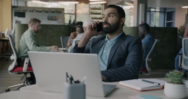Ofis Çalışanının Portresi Cep Telefonuyla Konuşuyor Yerinde Dizüstü Bilgisayarla Çalışıyor — Stok video