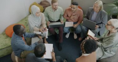 En iyi bakış açısına göre, kadın ve erkek meslektaşlar, rahat ofis odasında iş birliği hakkında fikir alışverişinde bulunuyorlar. İnsanlar ve iletişim konsepti.