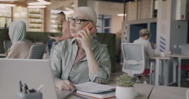 雄心勃勃的女商人在开放的办公室里用手机和阅读报纸 通信和工作场所概念 — 图库视频影像