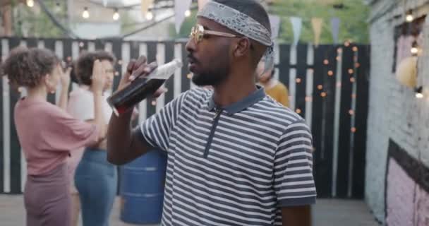 Portret Wesołego Afroamerykanina Pijącego Napój Butelki Świeżym Powietrzu Patrzącego Kamerę — Wideo stockowe
