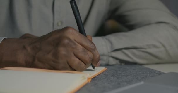 Närbild Manliga Händer Skriva Information Anteckningsboken Medan Afroamerikanska Mannen Arbetar — Stockvideo