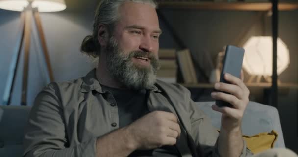 Ein Fröhlicher Mann Mittleren Alters Telefoniert Lachend Mit Einem Smartphone — Stockvideo