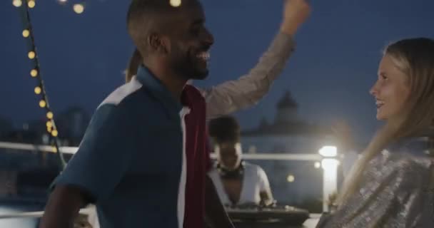 白种人女人和非裔美国男人在户外的屋顶派对上欢欢喜喜地跳舞 休闲和关系概念 — 图库视频影像