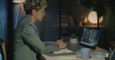 Kadın ofis çalışanı, iş yerindeki bilgisayarla sanal toplantı sırasında iş arkadaşı ile konuşuyor. İletişim ve iş konsepti.