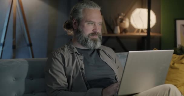 Сидящий Дома Диване Мужчина Средних Лет Работает Ноутбуком Современные Технологии — стоковое видео