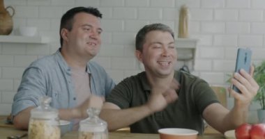 Tasasız eşcinseller evdeki akıllı telefonlarıyla online video görüşmelerini onaylıyor. İnsanlar ve iletişim konsepti.