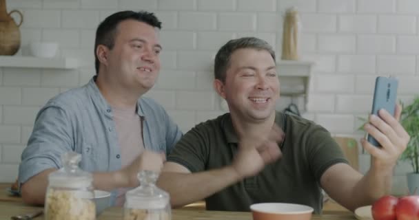 Unbekümmerte Schwule Männer Die Der Heimischen Küche Mit Dem Smartphone — Stockvideo