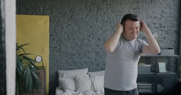 Kulaklık Takan Dans Eden Yatak Odasında Müzik Dinleyen Neşeli Genç — Stok video