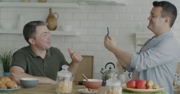 一对顽皮的同性恋夫妇正在公寓的厨房里拍照 摆出一副智能手机相机的样子 同性关系和摄影概念 — 图库视频影像