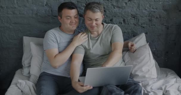 中年男人喜欢同性恋夫妇在床上抱着笔记本电脑 享受网上内容 Lgbtq关系和现代技术概念 — 图库视频影像