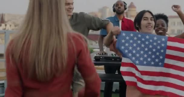 Американские Патриоты Танцующие Национальным Флагом Сша Наслаждаются Вечеринкой Крыше Вместе — стоковое видео
