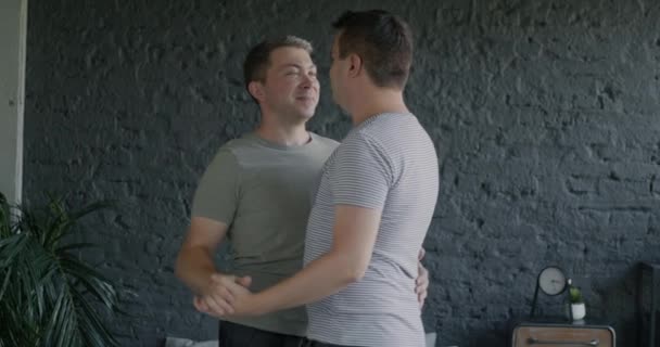 愛するゲイカップルハンサムな男性は 自宅でロマンチックな瞬間を楽しむ愛を表現する手を握って寝室で踊ります Lgbtqの人々と同性愛のコンセプト — ストック動画