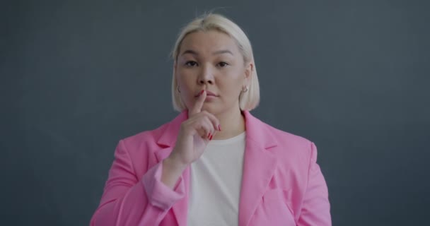 Asyalı Kadınının Parmaklarıyla Dudaklara Kulaklara Dokunarak Gri Arka Planda Sessizlik — Stok video