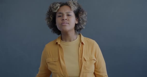 Медленный Портрет Улыбающейся Афроамериканки Смотрящей Камеру Делающей Бинокль Жест Рукой — стоковое видео