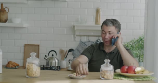 Alegre Gay Homem Bate Papo Celular Sentado Cozinha Mesa Enquanto — Vídeo de Stock