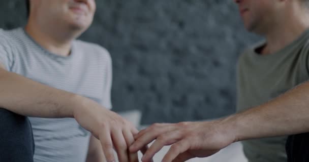 男同性恋手牵着手的特写 而男同性恋则坐在床上互相凝视着对方表达爱意 男女同性恋 双性恋和变性关系概念 — 图库视频影像