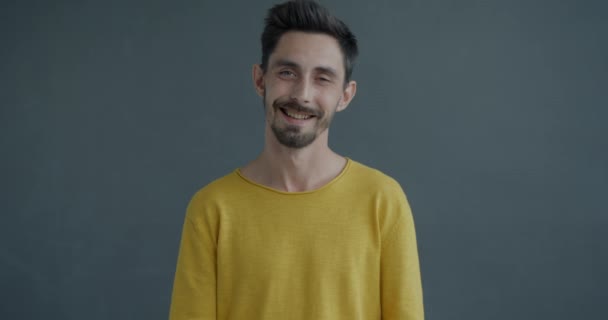 Powolny Portret Młodego Mężczyzny Pokazującego Niewielką Ilość Uśmiechniętymi Palcami Patrzącymi — Wideo stockowe