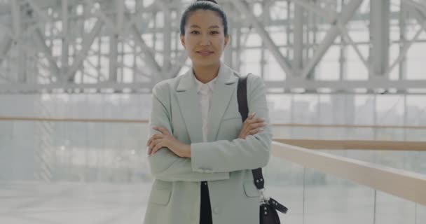 自信的亚洲女商人站在商务办公室大堂 微笑着看着相机的肖像 成功的行政人员穿着雅致的衣服 提着包 — 图库视频影像