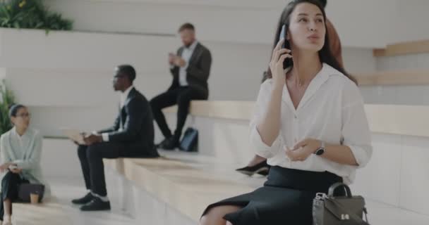 迷人的年轻女士在手机上谈论商务时坐在外面的楼梯上 现代技术和通信概念 — 图库视频影像