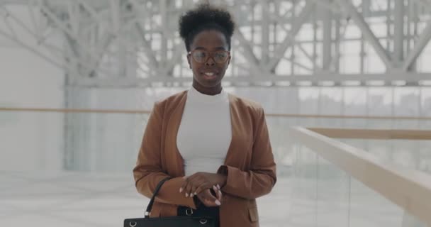 站在现代机场的积极的非洲裔美国妇女慢动作肖像 微笑着提包 商务旅行与成功的人的概念 — 图库视频影像
