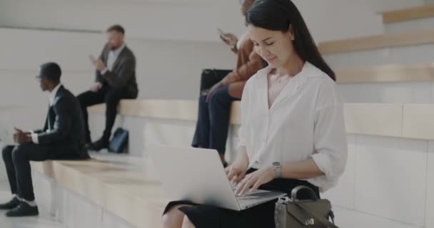 在阳光明媚的夏日 一位优雅的商务女士坐在室外的楼梯上 用笔记本电脑打字 现代设备和成功人士的概念 — 图库视频影像
