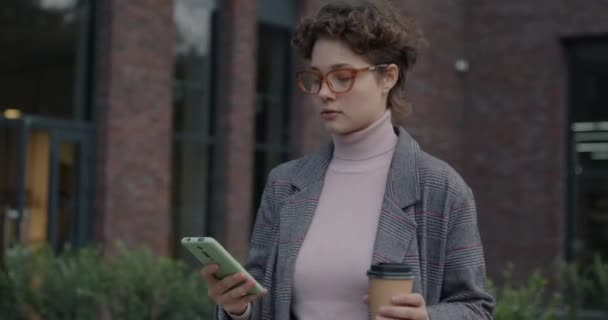 Fröhliche Junge Frau Die Mit Dem Smartphone Auf Der Straße — Stockvideo