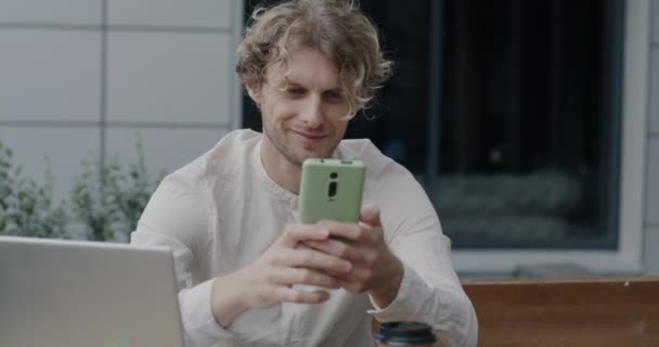 Счастливый Молодой Бизнесмен Общается Смартфоном Помощью Мобильного Приложения Уличном Кафе — стоковое видео